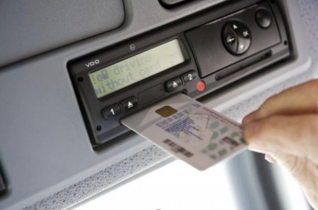 Chauffeur plaatst een bestuurderskaart in een digitale tachograaf voor tijdregistratie